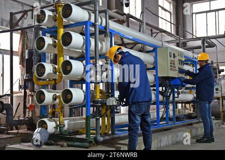 YANTAI, CHINE - 11 NOVEMBRE 2023 - Un membre du personnel d'une société d'énergie thermique exploite une unité d'osmose inverse de traitement de l'eau à Yantai, province de Shandong, Chine, le 11 novembre 2023. (Photo de Costfoto/NurPhoto) Banque D'Images