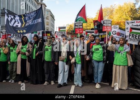 Des jeunes femmes mènent une partie de la manifestation contre la guerre à Gaza, avec des drapeaux et des pancartes palestiniens. Londres novembre 2023. Banque D'Images