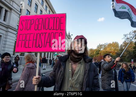 Jeune homme avec pancarte 'Stop génocide. Libérer les otages". Protestation contre la guerre à Gaza. Londres. Novemebr 2023 Banque D'Images