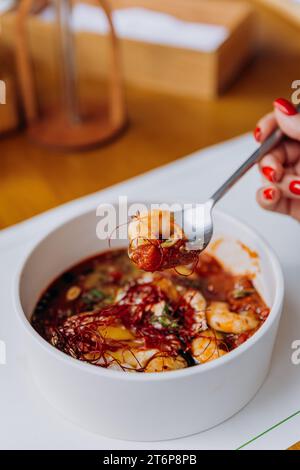 Gros plan de femme mangeant de la nourriture thaïlandaise de porridge de citrouille avec des crevettes dans le restaurant Banque D'Images