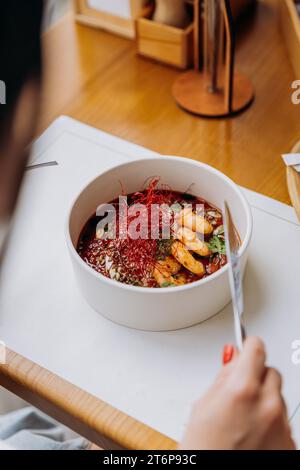 Gros plan de femme mangeant de la nourriture thaïlandaise de porridge de citrouille avec des crevettes dans le restaurant Banque D'Images