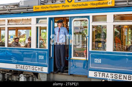 DAS Zürcher Tram - Elefant Ein Kontrolleur schaut ob alle Passagiere eingestiegen sind. DAS war in der Zeit des trams StStZ ce 4/4 321, welches 1930 an die Städtische Strasssenbahn Zürich abgeliefert wurde üblich. Besser bekannt ist das Tram unter dem Übername Elefant . 1966 wurde es ausrangiert und steht seit 1975 als Museumstram im Dienst der VBZ. Hier ist es auf der Linie 6 zwischen Zürich Hauptbahnhof und dem Zürich Zoo, anlässlich des Jubiläumsevents 175 Jahre Eisenbahn in der Schweiz im Einsatz. Zürich, Schweiz, 21.05.2022 *** le tramway de Zurich Elefant un inspecteur vérifie si tous Banque D'Images