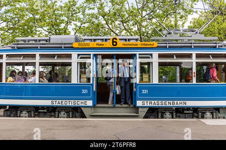 DAS Zürcher Tram - Elefant Ein Kontrolleur schaut ob alle Passagiere eingestiegen sind. DAS war in der Zeit des trams StStZ ce 4/4 321, welches 1930 an die Städtische Strasssenbahn Zürich abgeliefert wurde üblich. Besser bekannt ist das Tram unter dem Übername Elefant . 1966 wurde es ausrangiert und steht seit 1975 als Museumstram im Dienst der VBZ. Hier ist es auf der Linie 6 zwischen Zürich Hauptbahnhof und dem Zürich Zoo, anlässlich des Jubiläumsevents 175 Jahre Eisenbahn in der Schweiz im Einsatz. Zürich, Schweiz, 21.05.2022 *** le tramway de Zurich Elefant un inspecteur vérifie si tous Banque D'Images