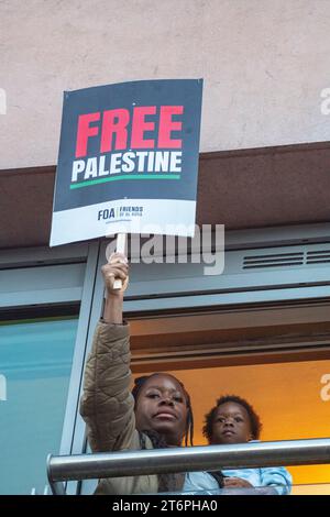 Londres, Royaume-Uni. 11 novembre 2023. Une mère et un enfant regardent des centaines de milliers de partisans palestiniens marcher à travers Londres Banque D'Images