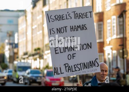 11 novembre 2023. Londres, Royaume-Uni. Un manifestant tenant le signe "la cible israélienne n'est pas le Hamas, c'est l'élimination de tous les Palestiniens marchant pacifiquement de Hyde Park à l'ambassade américaine à Nine Elms le jour de l'Armistice appelant à un cessez-le-feu immédiat au Moyen-Orient, où des milliers de civils innocents, dont de nombreux enfants, sont morts à la fois dans l'attaque du Hamas contre Israël et dans des attaques aériennes extrêmement punitives qui ont dévasté de vastes zones de Gaza.Credit image : © Horst Friedrichs Banque D'Images