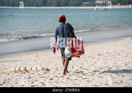 Vendeur de crème glacée sur la plage marche le long de la rive. Thaïlande, Phuket Banque D'Images