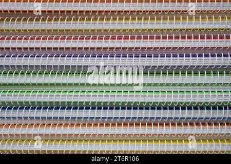 Motif texturé de cahiers colorés en spirale. Pile de fournitures de bureau et d'éducation Banque D'Images