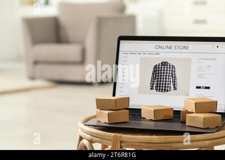Boutique en ligne. Ordinateur portable et mini colis sur la table à l'intérieur, espace pour le texte Banque D'Images