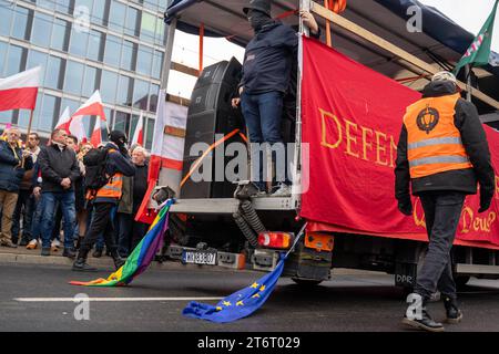 LGBT et un drapeau de l Union européenne tirés par une voiture lors de la célébration du 105e anniversaire de l indépendance de la Pologne à Varsovie, le 11 novembre 2023. Des milliers de personnes se sont rassemblées dans la capitale polonaise, Varsovie, lors de la marche annuelle controversée du jour de l'indépendance organisée par les groupes de jeunes d'extrême droite et nationalistes Wszechpolska et ONR Nationalist-radical Camp à l'occasion de la reprise de l'indépendance de la Pologne. 105e jour de l'indépendance de la Pologne à Varsovie Copyright : xMarekxAntonixIwanczukx MAI00674 Banque D'Images
