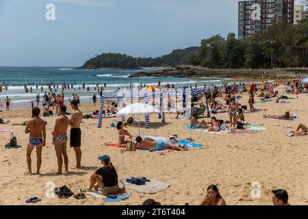 Manly Beach à Sydney Australie Plage bondée le jour de printemps avec quelques-uns sous la cabane de plage pour fournir de l'ombre et une protection solaire Banque D'Images