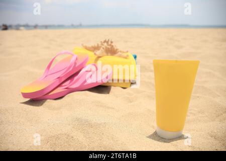 Tube de crème solaire, accessoires de plage et étoiles de mer sur sable, mise au point sélective. Soins de protection solaire Banque D'Images