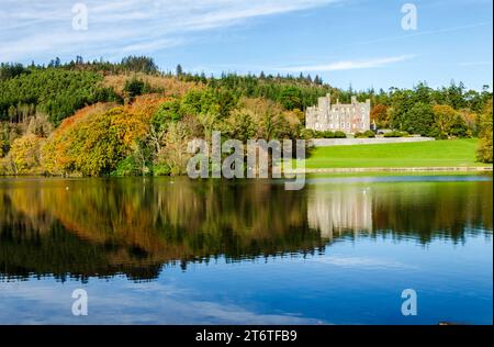 Castlewellan, County Down, Irlande du Nord novembre 11 2023 - Château de Castlewellan vu de l'autre côté du lac avec reflets et couleurs automnales Banque D'Images
