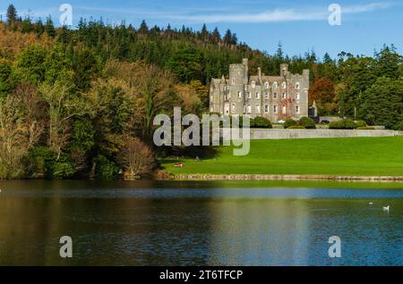 Castlewellan, County Down, Irlande du Nord novembre 11 2023 - Château de Castlewellan vu de l'autre côté du lac avec reflets et couleurs automnales Banque D'Images