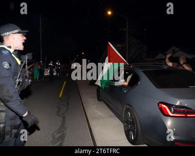 Un officier de police crie à un chauffeur de déplacer sa voiture arborant un drapeau palestien alors qu'il s'arrête sur la route devant des contre-manifestants pro-israéliens après qu'un restaurant de la chaîne Burgertory appartenant à la palestino-australienne Hesham Tayah ait brûlé pendant la nuit dans la banlieue la plus juive de Melbourne, des manifestants pro-palestiniens se sont rassemblés dans un parc voisin où des échanges violents ont eu lieu avec des contre-manifestants pro-israéliens. La police a déployé du gaz poivré des deux côtés et a procédé à une arrestation. (Photo Alex Zucco / SOPA Images/Sipa USA) Banque D'Images