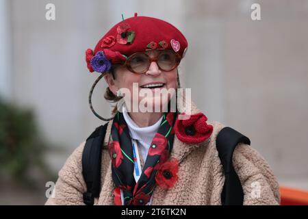 Londres, Royaume-Uni. 12 novembre 2023. Une femme couverte de coquelicots sur le Mall dans le centre de Londres avant un service est tenu au cénotaphe sur Whitehall à Westminster le dimanche du souvenir. Des milliers de personnes honorent les morts de guerre en se rassemblant au mémorial emblématique pour déposer des couronnes et observer deux minutes de silence. Crédit photo : Ben Cawthra/Sipa USA crédit : SIPA USA/Alamy Live News Banque D'Images