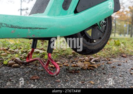 Un vélo-scooter vert placé sur sa jambe en position d'arrêt Banque D'Images