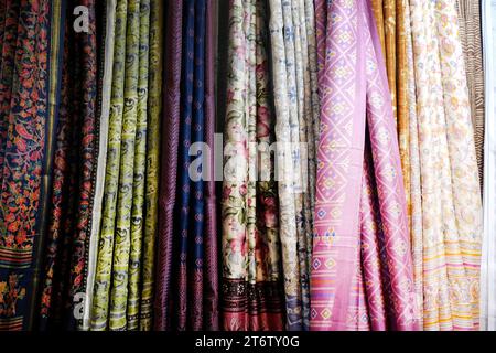 Sarees indiennes de fantaisie, saris en soie colorés soigneusement empilés dans des casiers dans une boutique de textiles. Incroyable Inde. Banque D'Images