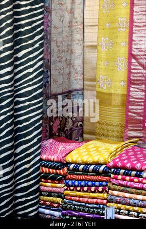 Sarees indiennes de fantaisie, saris en soie colorés soigneusement empilés dans des casiers dans une boutique de textiles. Incroyable Inde. Banque D'Images