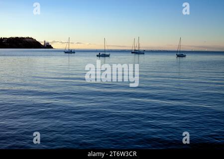 Bateaux à voile en soirée coucher de soleil sur la mer calme dans la baie de Piran près du parc naturel Strunjan dans la mer Adriatique du Nord sur la côte slovène Banque D'Images