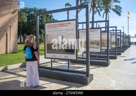 Touriste féminin regardant les photographies d'archives affichées dans la ville de Cartagena Espagne Banque D'Images