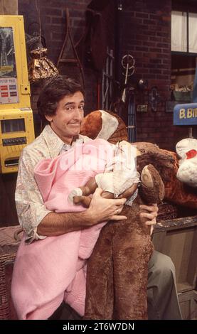 Une photo de 1977 du tournage de Sesame Street avec l'acteur Bob McGrath qui a joué Ben Johnson faisant un visage tout en tenant un grand chien en peluche. Dans un studio sur Broadway dans l'Upper West Side de Manhattan. Banque D'Images