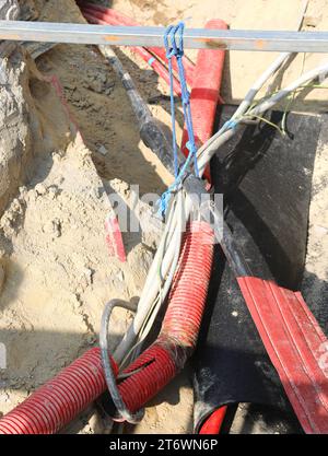 jonction électrique entre des câbles électriques haute tension à l'intérieur de l'excavation d'un chantier de construction routière pour la réparation de la ligne électrique Banque D'Images