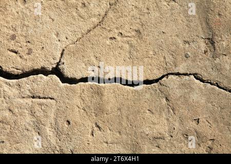 Fissure dans le revêtement en béton d'une vieille maison. Surface rugueuse et irrégulière. Plâtre de ciment sur un mur de briques, texture, fond. Toile de fond ancienne Banque D'Images