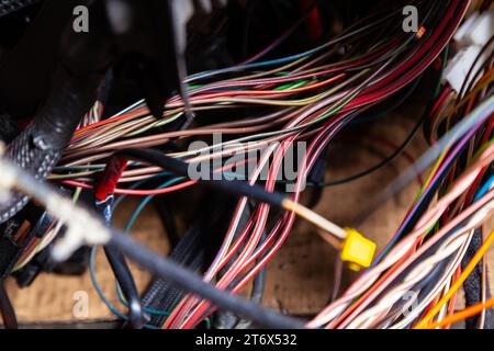 Un câble de fils matés de différentes couleurs avec des connecteurs dans le câblage électrique de la voiture. Ligne Internet dans le travail du fournisseur. Banque D'Images