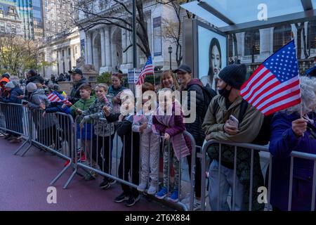 NEW YORK, NEW YORK - 11 NOVEMBRE : les spectateurs tiennent une pancarte et des drapeaux lors du défilé annuel de la Journée des anciens combattants le 11 novembre 2023 à New York. Des centaines de personnes ont bordé la 5e Avenue pour assister au plus grand défilé de la Journée des anciens combattants aux États-Unis. Cette année, l’événement comprenait des vétérans, des soldats actifs, des policiers, des pompiers et des dizaines de groupes scolaires participant à la parade qui honore les hommes et les femmes qui ont servi et sacrifié pour le pays. (Photo Ron Adar / SOPA Images/Sipa USA) Banque D'Images
