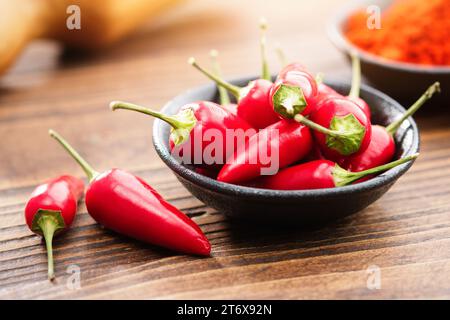 Bol de gousses de piment rouge et piment rouge moulu en poudre sur fond. Banque D'Images