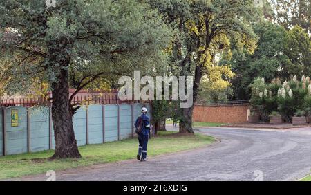 Johannesburg, Afrique du Sud - un travailleur noir non identifié rentre chez lui en passant par une banlieue de la ville Banque D'Images