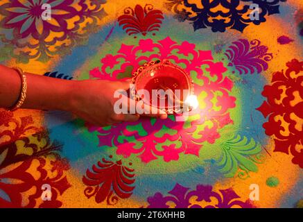 Assam, Inde. 12 novembre 2023. Lampe à huile allumée par femme sur un rongoli, à l'occasion du festival Diwali, la fête hindoue des lumières, à Guwahati, Assam, Inde, le 12 novembre 2023. Crédit : David Talukdar/Alamy Live News Banque D'Images