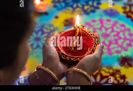 Assam, Inde. 12 novembre 2023. Une femme tient une lampe à huile vêtue d'un costume traditionnel à l'occasion du festival Diwali, la fête hindoue des lumières, à Guwahati, Assam (Inde), le 12 novembre 2023. Crédit : David Talukdar/Alamy Live News Banque D'Images