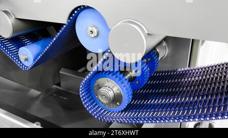 L'arbre d'entraînement de la chaîne d'engrenages de la courroie du convoyeur se trouve sur la chaîne de production. Chaîne de distribution du véhicule, tendeurs dans le moteur. Chaîne à rouleaux industrielle, technologie. L'équipe va Banque D'Images