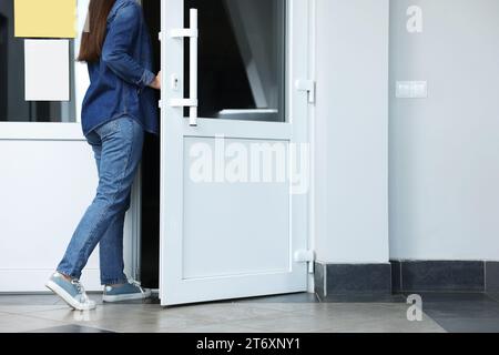 Femme en vêtements décontractés quittant ou entrant dans le bâtiment, closeup Banque D'Images