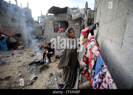 Rafah, Gaza. 12 novembre 2023. Amal al al-Robayaa 44, étalé les vêtements au milieu des ruines de la maison familiale détruite lors d’une frappe israélienne à Rafah, dans le Sud de la bande de Gaza, le dimanche 7 novembre 2023. Robayaa dit que l'immeuble dans lequel il vivait a été détruit par un bombardement israélien le 7 octobre, le premier jour de la guerre à Gaza. Amal Rabayaa, mari d’Imad, s’infiltre maintenant avec d’autres membres de sa famille dans une école des Nations Unies à Rafah, mais rentre chez elle le matin et fait face à la lutte quotidienne pour trouver de la nourriture et de l’eau. Photo par Ismael Mohamad/UPI crédit : UPI/Alamy Live News Banque D'Images