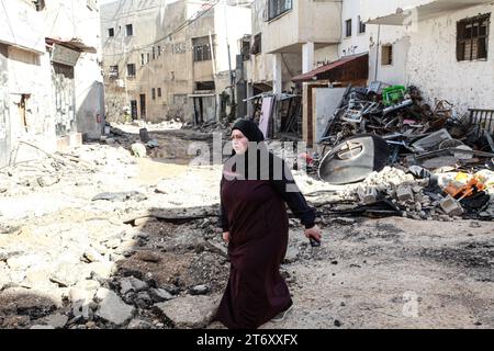 Une femme marche à travers les décombres d’un bâtiment détruit après un raid militaire israélien dans le camp de réfugiés de Djénine, en Cisjordanie. Banque D'Images