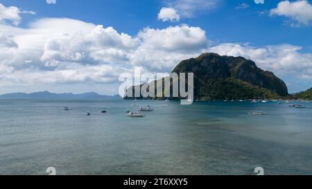 Un paysage pittoresque avec plusieurs bateaux flottant sur l'océan tranquille sur une journée avec un ciel partiellement nuageux Banque D'Images