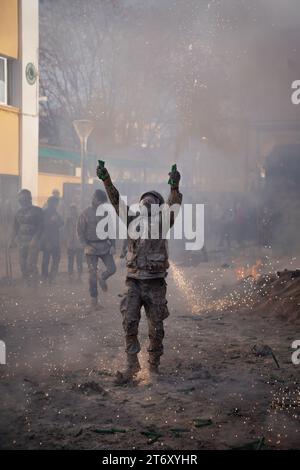 IBI, Espagne - 28 décembre 2022 : Homme habillé en soldat avec des feux d'artifice dans les mains lors d'une bataille traditionnelle de farine à Ibi, en Espagne Banque D'Images