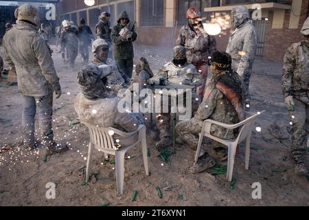 IBI, Espagne - 28 décembre 2022 : les participants à la traditionnelle bataille de farine Ibi s'assoient à la table pour négocier la fin de la bataille entre feux d'artifice Banque D'Images