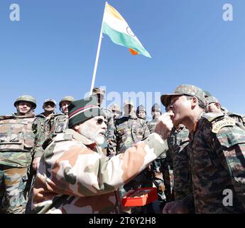 Lepcha, Inde. 12 novembre 2023. Le Premier ministre indien Narendra Modi, à gauche, donne un bonbon à un soldat indien pour célébrer le festival de Diwali lors d'une visite avec des soldats dans une base himalayenne isolée, le 12 novembre 2023 à Lepcha, Himachal Pradesh, en Inde. Crédit : PIB photo/Press information Bureau/Alamy Live News Banque D'Images