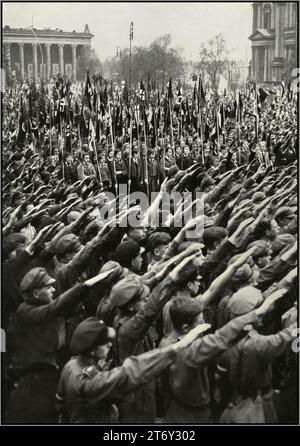 Rassemblement de la jeunesse de l'Allemagne nazie des années 1930 dans le jardin de plaisance de Berlin, avec drapeau swastika portant la Ligue des filles allemandes BDM et HitlerJugend Hitler Youth donnant au parti nazi Heil Hitler salut à Fuhrer Adolf Hitler. « L'Allemagne réveille » la montée du nazisme en Allemagne des années 1930 Banque D'Images