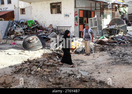 10 novembre 2023, Djénine, Palestine : une femme marche à travers les décombres d’un bâtiment détruit après un raid militaire israélien dans le camp de réfugiés de Djénine en Cisjordanie. (Image de crédit : © Nasser Ishtayeh/SOPA Images via ZUMA Press Wire) USAGE ÉDITORIAL SEULEMENT! Non destiné à UN USAGE commercial ! Banque D'Images