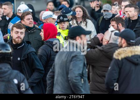 Une femme policière inquiète parmi les manifestants marqués comme étant d'extrême droite tentant d'arrêter une manifestation pro Palestine à Londres, au Royaume-Uni, le jour de l'Armistice Banque D'Images