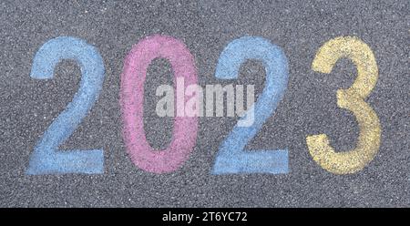 Commencez la nouvelle année 2023 au pochoir dans la peinture de chaussée sur l'asphalte, commencez le concept de voyage. Voyage de célébration dans les numéros du nouvel an Banque D'Images