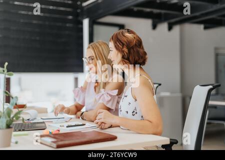 Deux femmes entrepreneurs ayant une réunion zoom dans le bureau. Banque D'Images