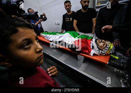 Djénine, Palestine. 12 novembre 2023. (NOTE DE LA RÉDACTION : l'image représente la mort)parents et hommes armés pleurent à côté du corps d'Amer Arqawi pendant ses funérailles, un jour après qu'il aurait été tué lors d'un raid israélien dans la ville de Djénine en Cisjordanie. Selon le Ministère palestinien de la santé, un palestinien a été tué et trois autres ont été blessés lors d ' affrontements avec les troupes israéliennes. Depuis le 07 octobre 2023, 185 Palestiniens ont été tués et plus de 2 000 blessés en Cisjordanie. Crédit : SOPA Images Limited/Alamy Live News Banque D'Images