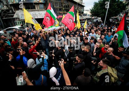 Djénine, Palestine. 12 novembre 2023. (NOTE DE LA RÉDACTION : l'image représente la mort)les personnes en deuil portent le corps d'Amer Arqawi lors de ses funérailles, un jour après qu'il ait été tué lors d'un raid israélien dans la ville de Djénine en Cisjordanie. Selon le Ministère palestinien de la santé, un palestinien a été tué et trois autres ont été blessés lors d ' affrontements avec les troupes israéliennes. Depuis le 07 octobre 2023, 185 Palestiniens ont été tués et plus de 2 000 blessés en Cisjordanie. Crédit : SOPA Images Limited/Alamy Live News Banque D'Images