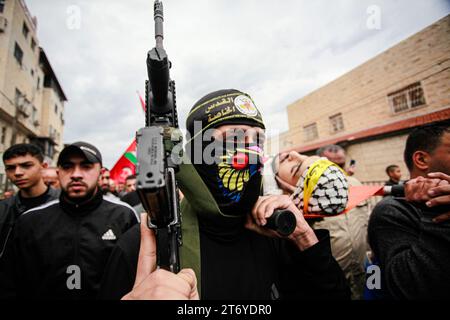 Djénine, Palestine. 12 novembre 2023. (NOTE DE LA RÉDACTION : l'image représente la mort)des hommes armés portent le corps d'Amer Arqawi lors de ses funérailles, un jour après qu'il ait été tué lors d'un raid israélien dans la ville de Djénine en Cisjordanie. Selon le Ministère palestinien de la santé, un palestinien a été tué et trois autres ont été blessés lors d ' affrontements avec les troupes israéliennes. Depuis le 07 octobre 2023, 185 Palestiniens ont été tués et plus de 2 000 blessés en Cisjordanie. Crédit : SOPA Images Limited/Alamy Live News Banque D'Images