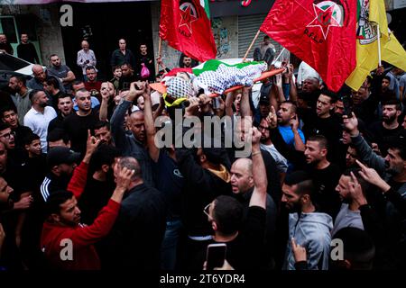 Djénine, Palestine. 12 novembre 2023. (NOTE DE LA RÉDACTION : l'image représente la mort)les personnes en deuil portent le corps d'Amer Arqawi lors de ses funérailles, un jour après qu'il ait été tué lors d'un raid israélien dans la ville de Djénine en Cisjordanie. Selon le Ministère palestinien de la santé, un palestinien a été tué et trois autres ont été blessés lors d ' affrontements avec les troupes israéliennes. Depuis le 07 octobre 2023, 185 Palestiniens ont été tués et plus de 2 000 blessés en Cisjordanie. Crédit : SOPA Images Limited/Alamy Live News Banque D'Images